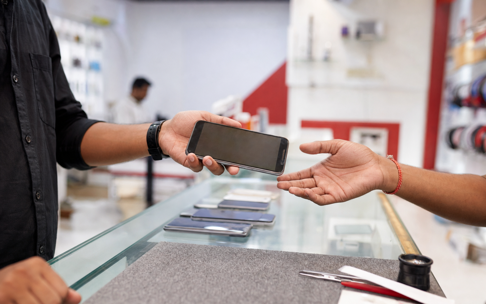 Customer handing a used smartphone to the Phonlelo team for inspection